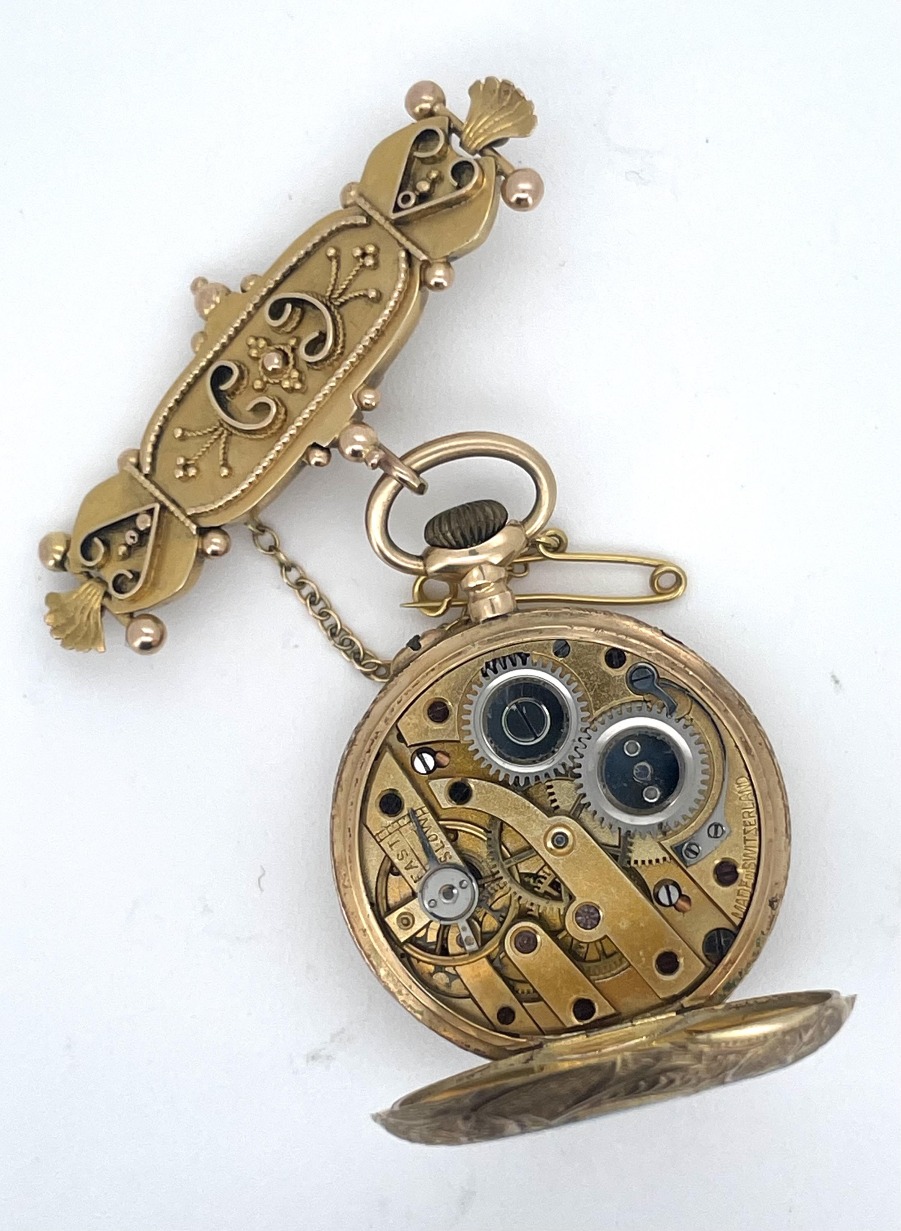 A lady's gold and Swiss enamel fob watch, circa 1907, the cream dial with gold enamel decoration and Arabic numeral indicators, the case with scrolled decoration, the reverse depicting a woman and lamb in a pastoral scen